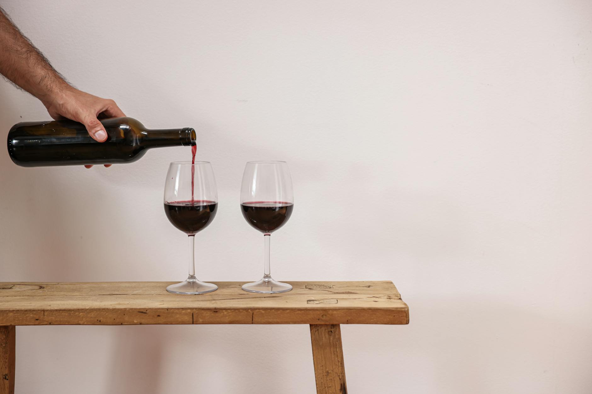 Rotwein wird in Gläser eingeschenkt